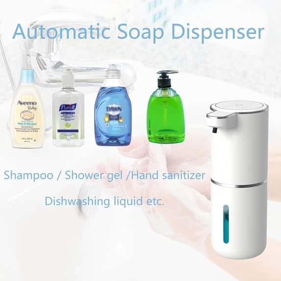 A white automatic touchless soap dispenser next to various soap bottles in a bathroom setting with soapy hands visible.