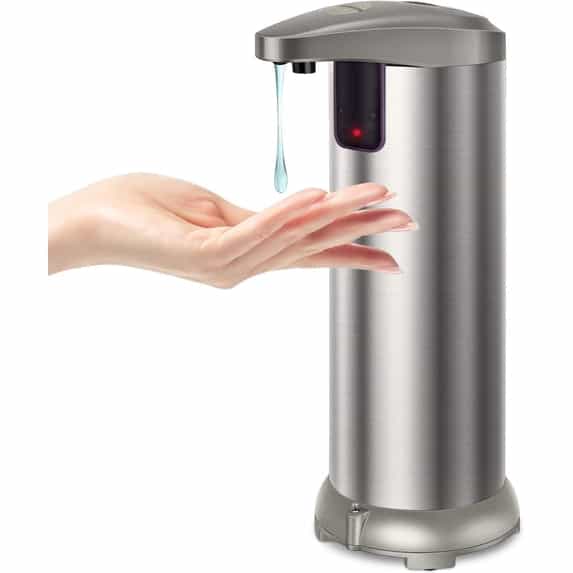 A stainless steel touchless soap dispenser dispensing liquid soap onto a hand against a white background.